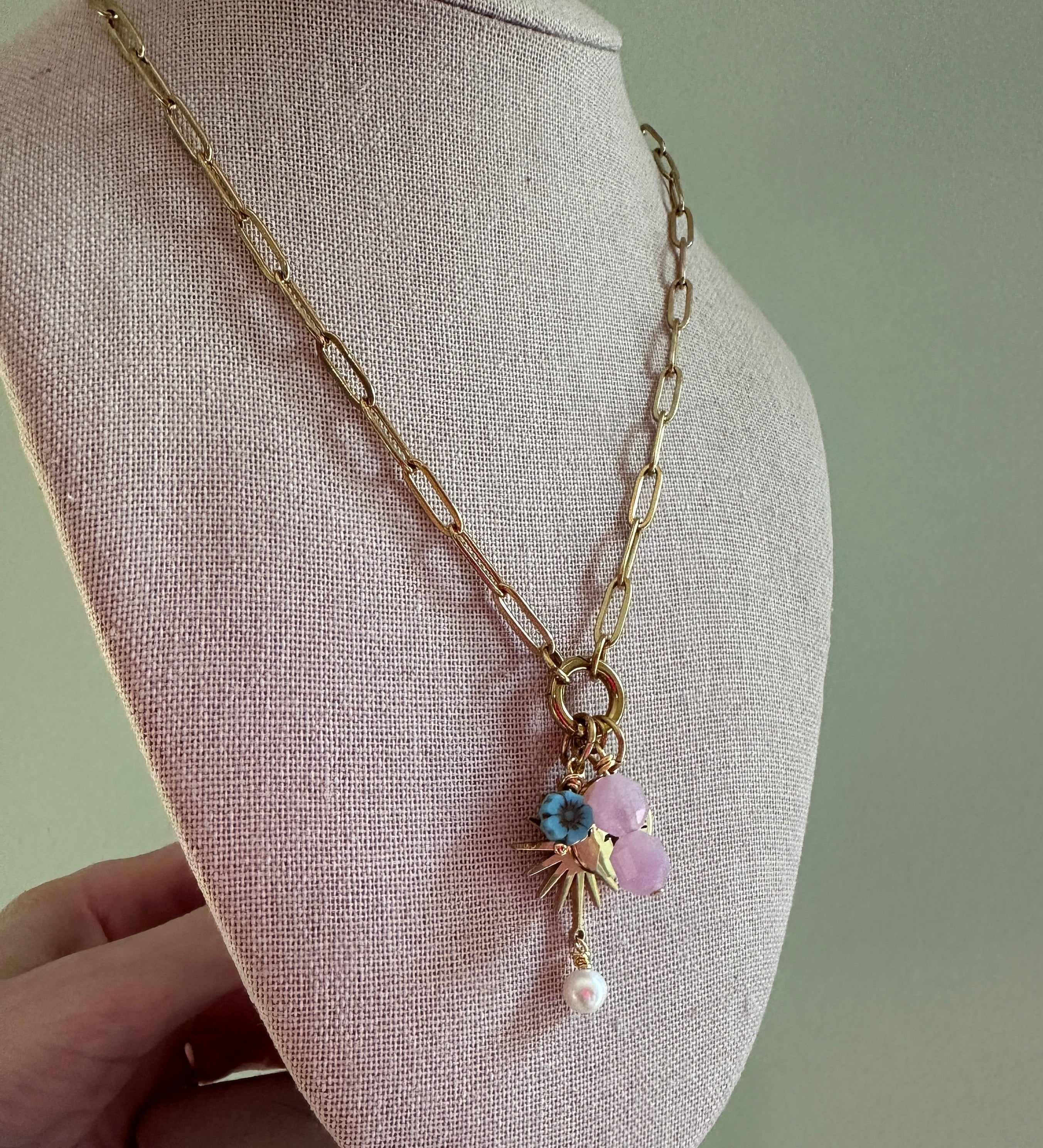 Delicate gold bracelet with beads on a gray fabric surface