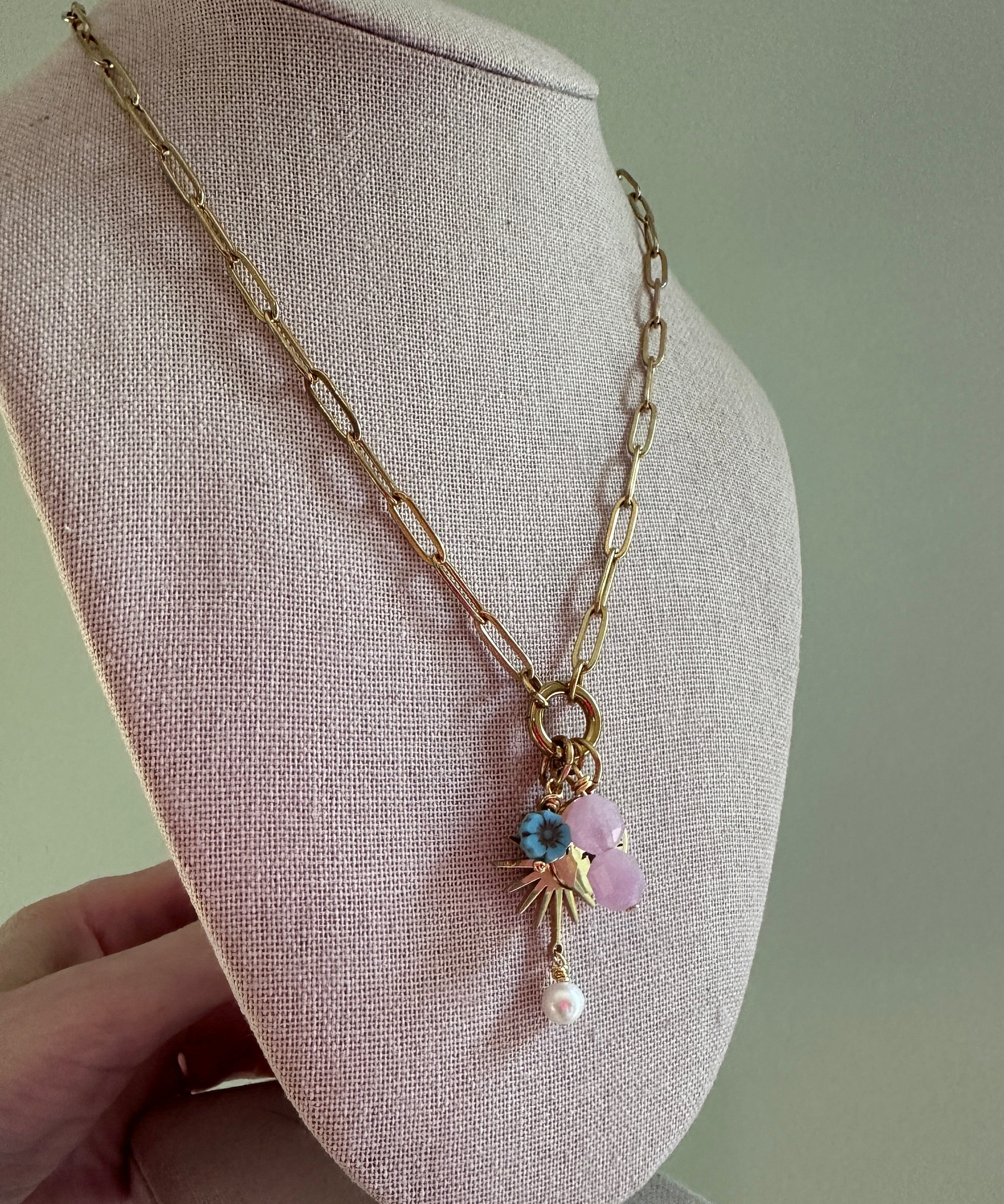 Delicate gold bracelet with beads on a gray fabric surface