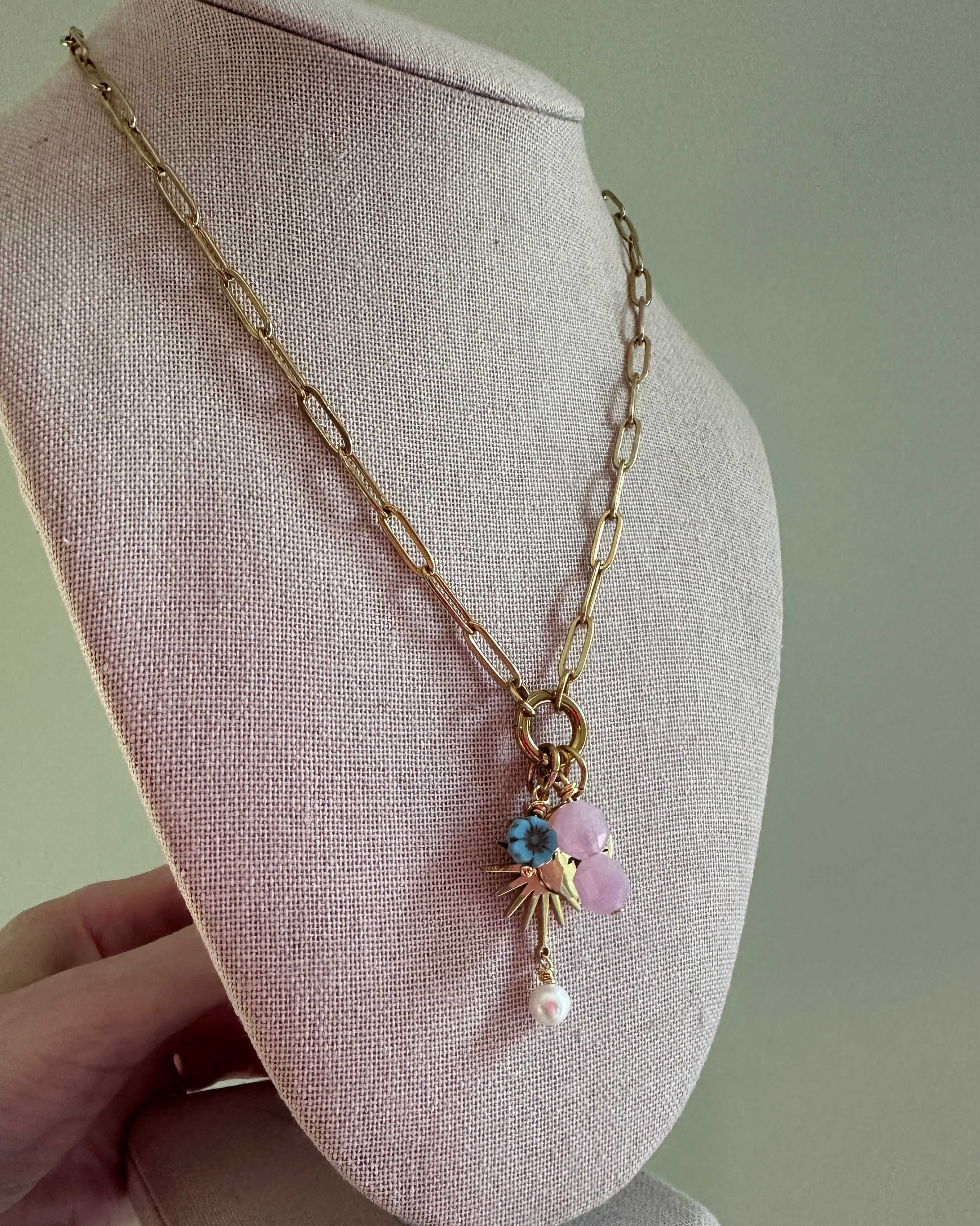 Delicate gold bracelet with beads on a gray fabric surface