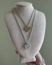 Necklace with heart-shaped pendants on a mannequin bust against a gray background