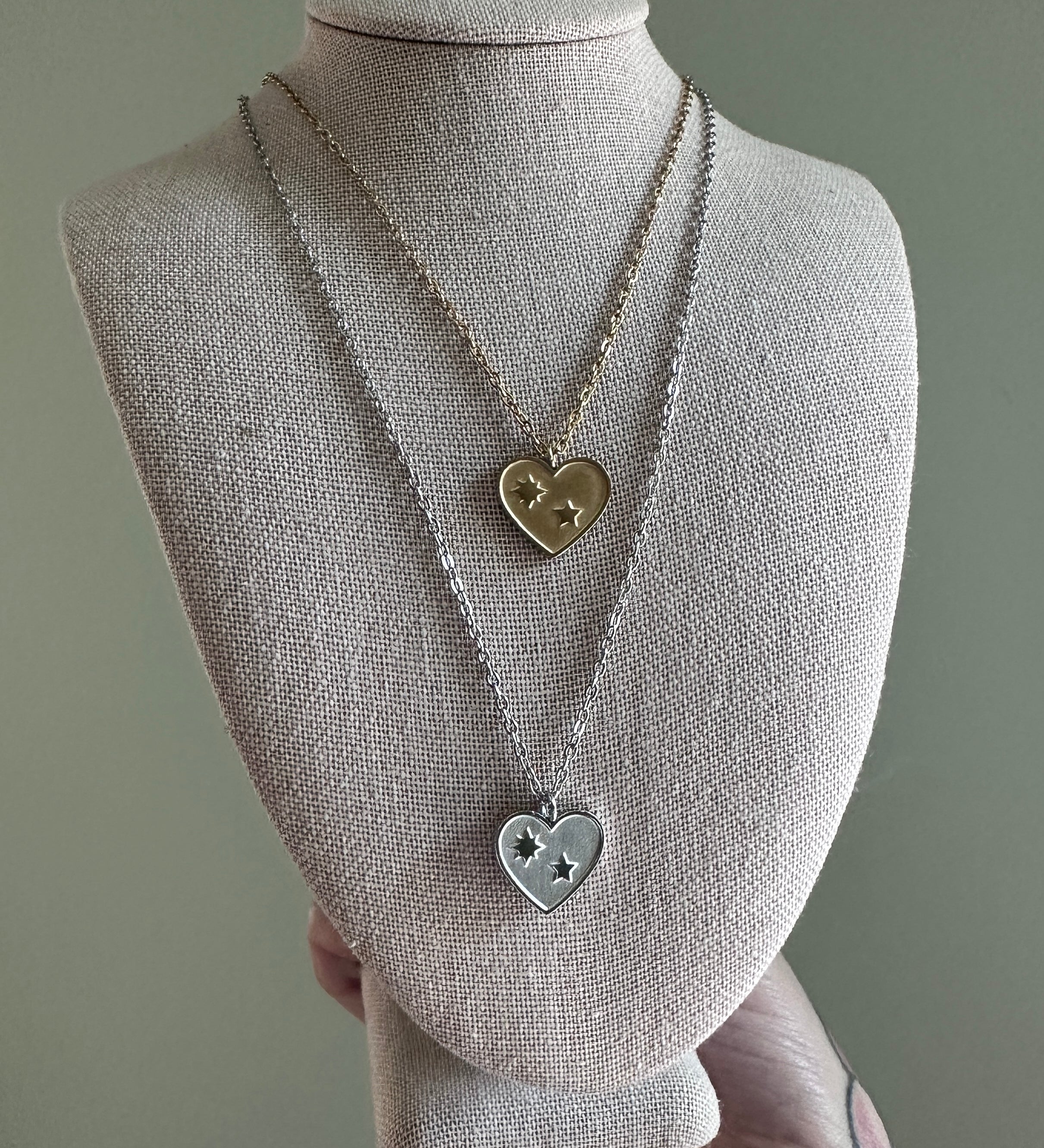 Necklace with heart-shaped pendants on a mannequin bust against a gray background