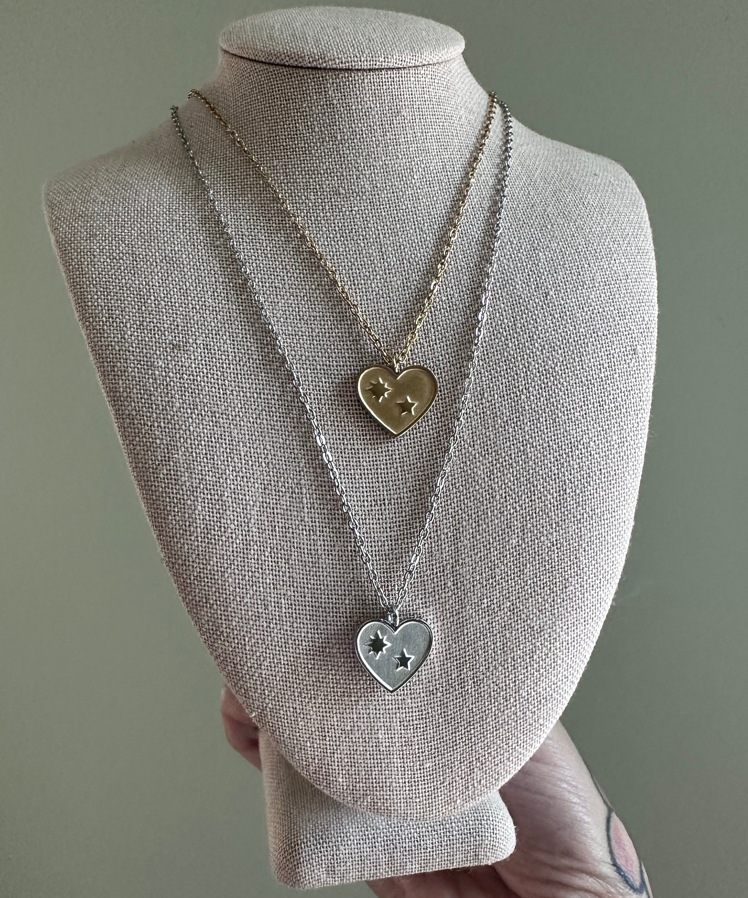 Necklace with heart-shaped pendants on a mannequin bust against a gray background