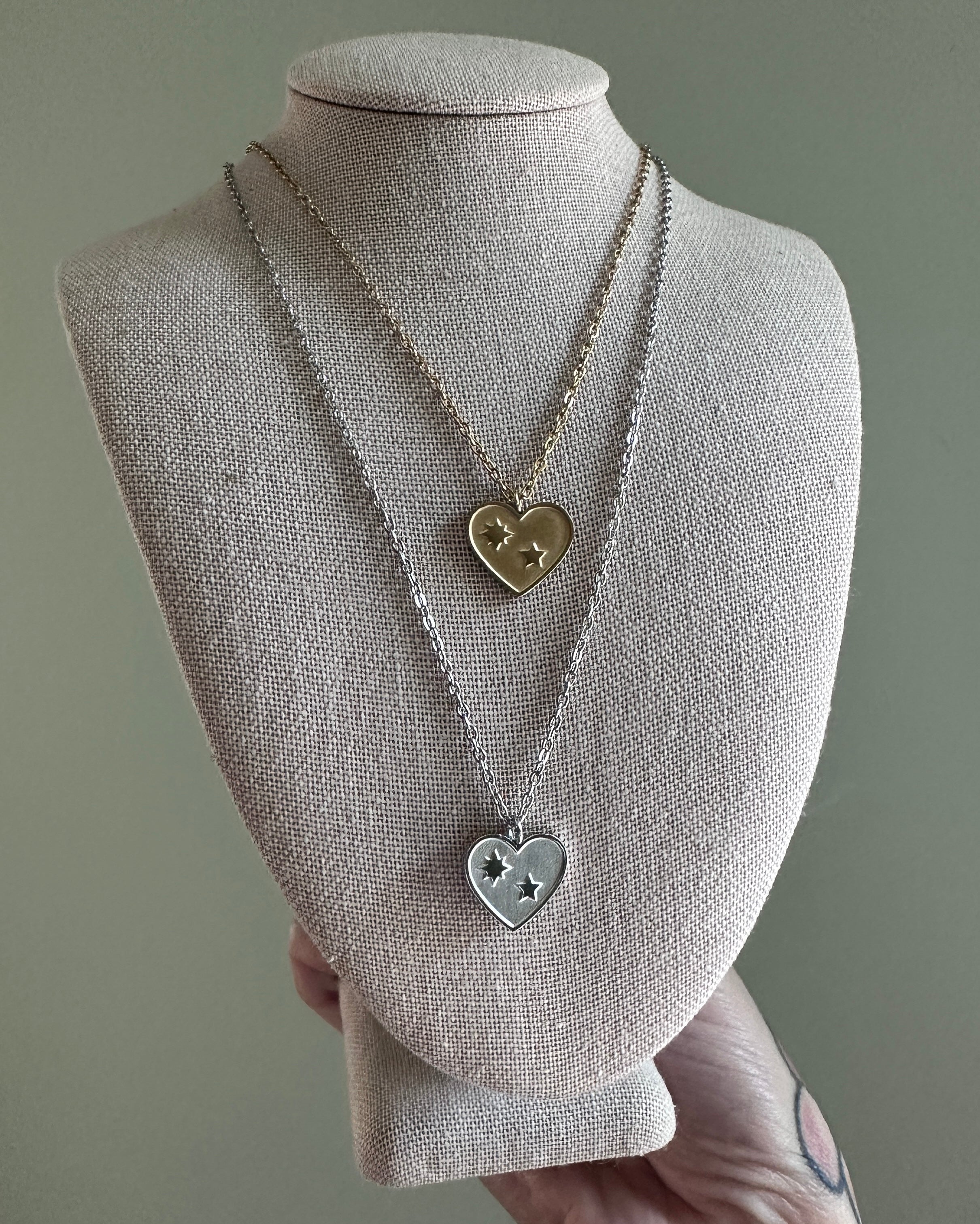 Necklace with heart-shaped pendants on a mannequin bust against a gray background