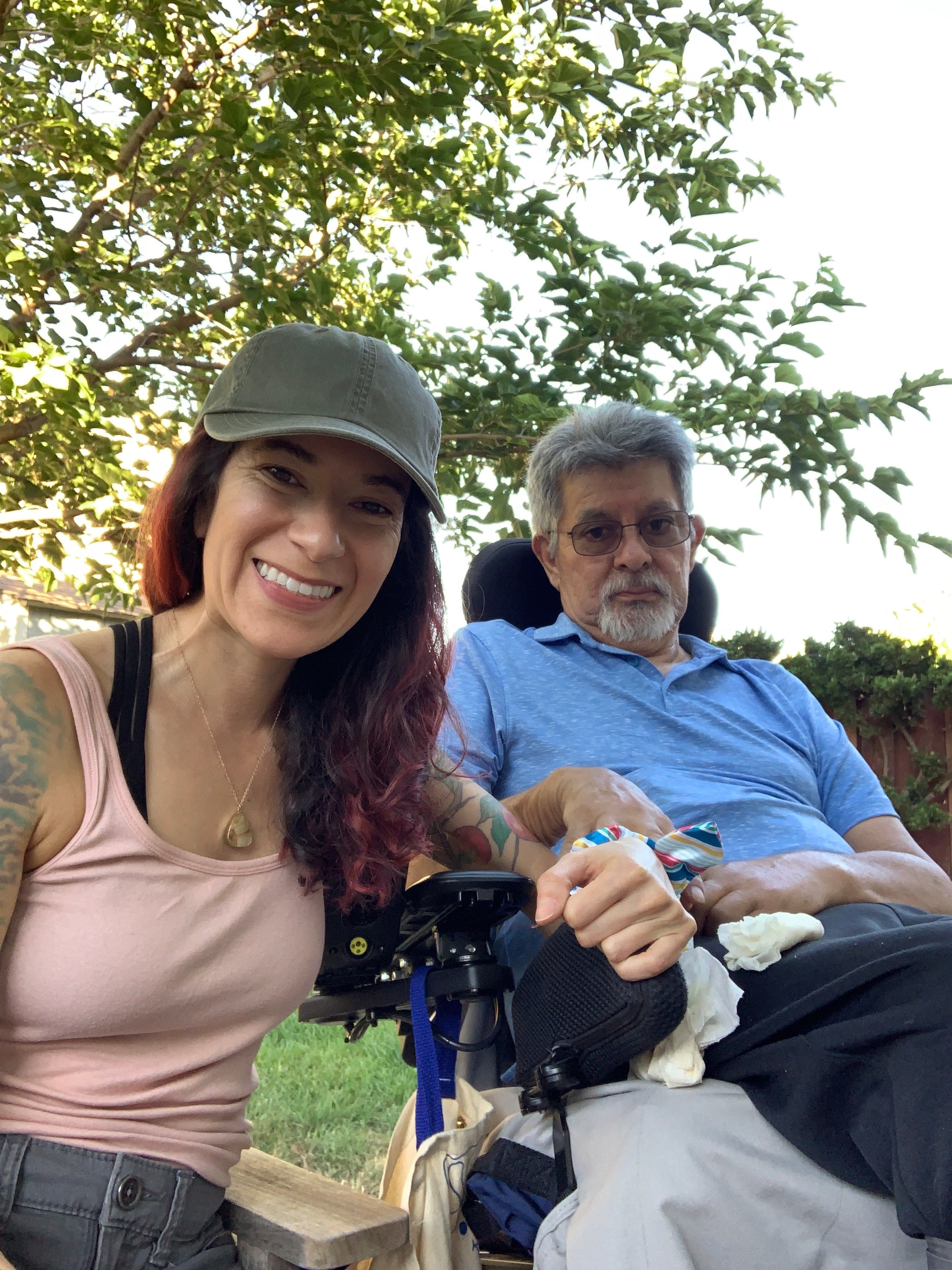 Two people standing outdoors with trees in the background