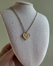 Heart-shaped pendant necklace on a mannequin bust against a neutral background
