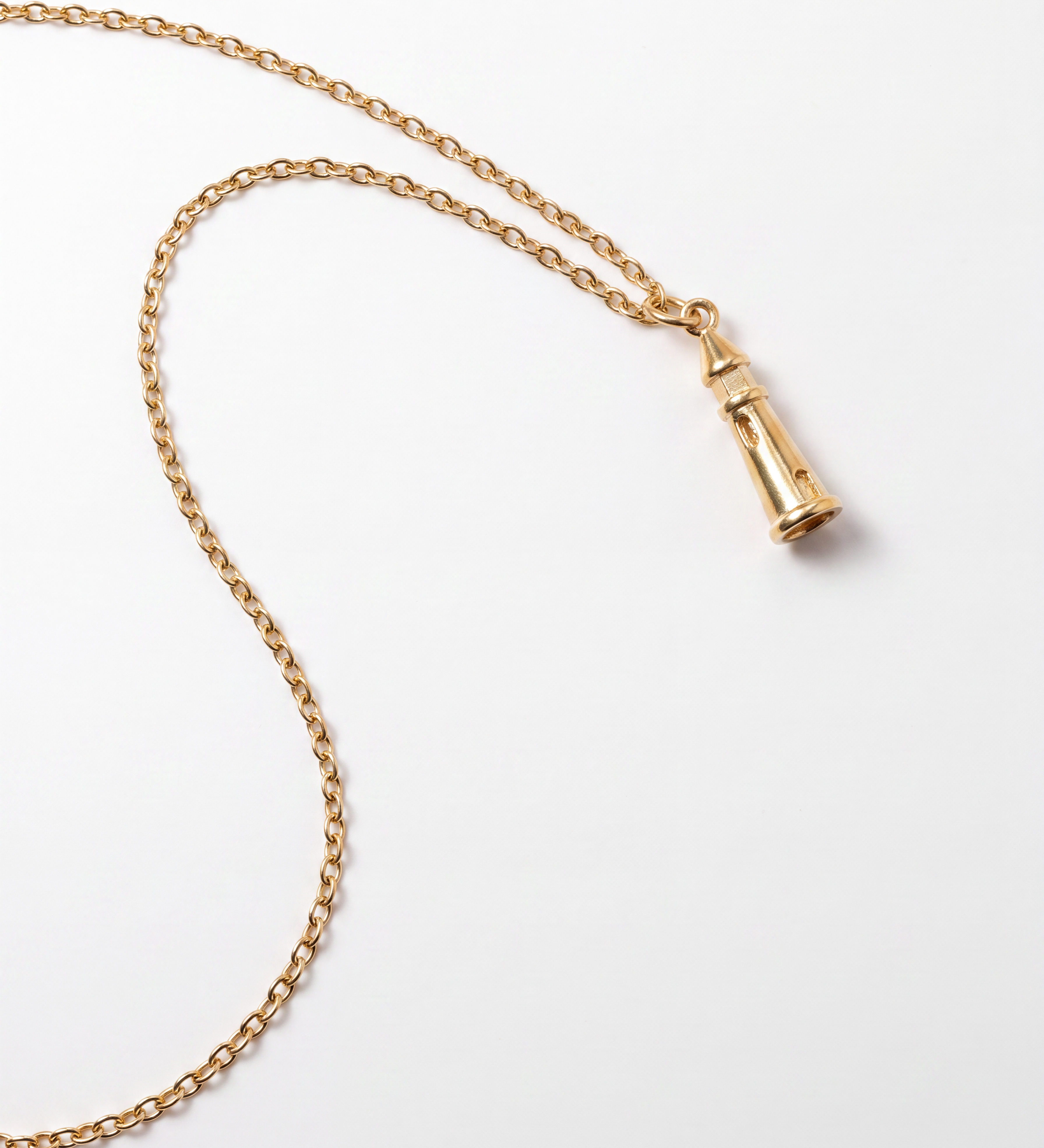 A gold chain necklace with a small lighthouse pendant, photographed on a clean white background.