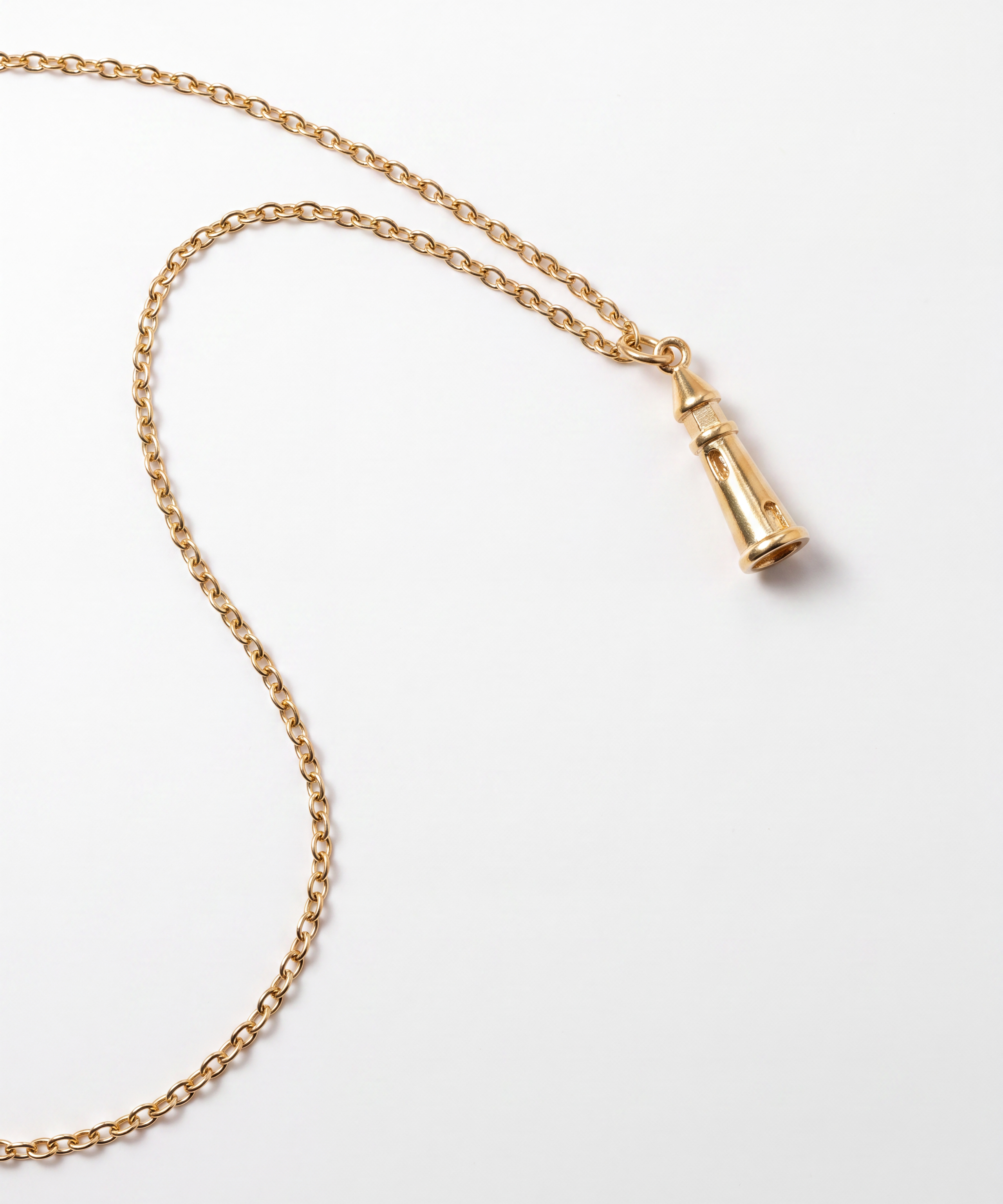 A gold chain necklace with a small lighthouse pendant, photographed on a clean white background.