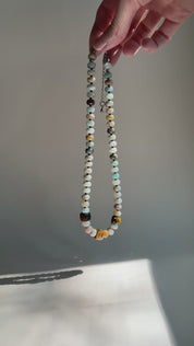 video of hand holding amazonite necklace in the sun